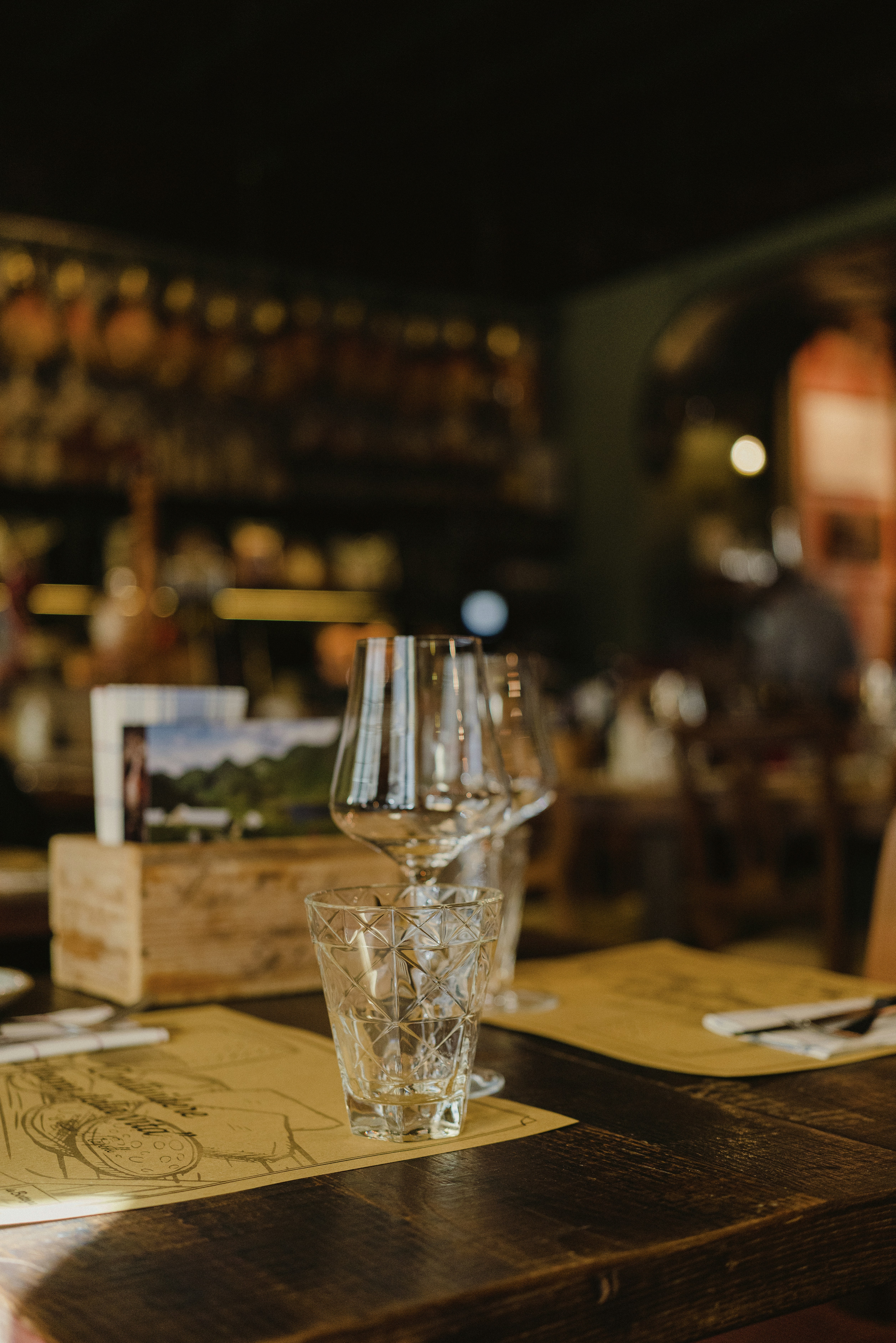 a wooden table topped with a glass filled with water