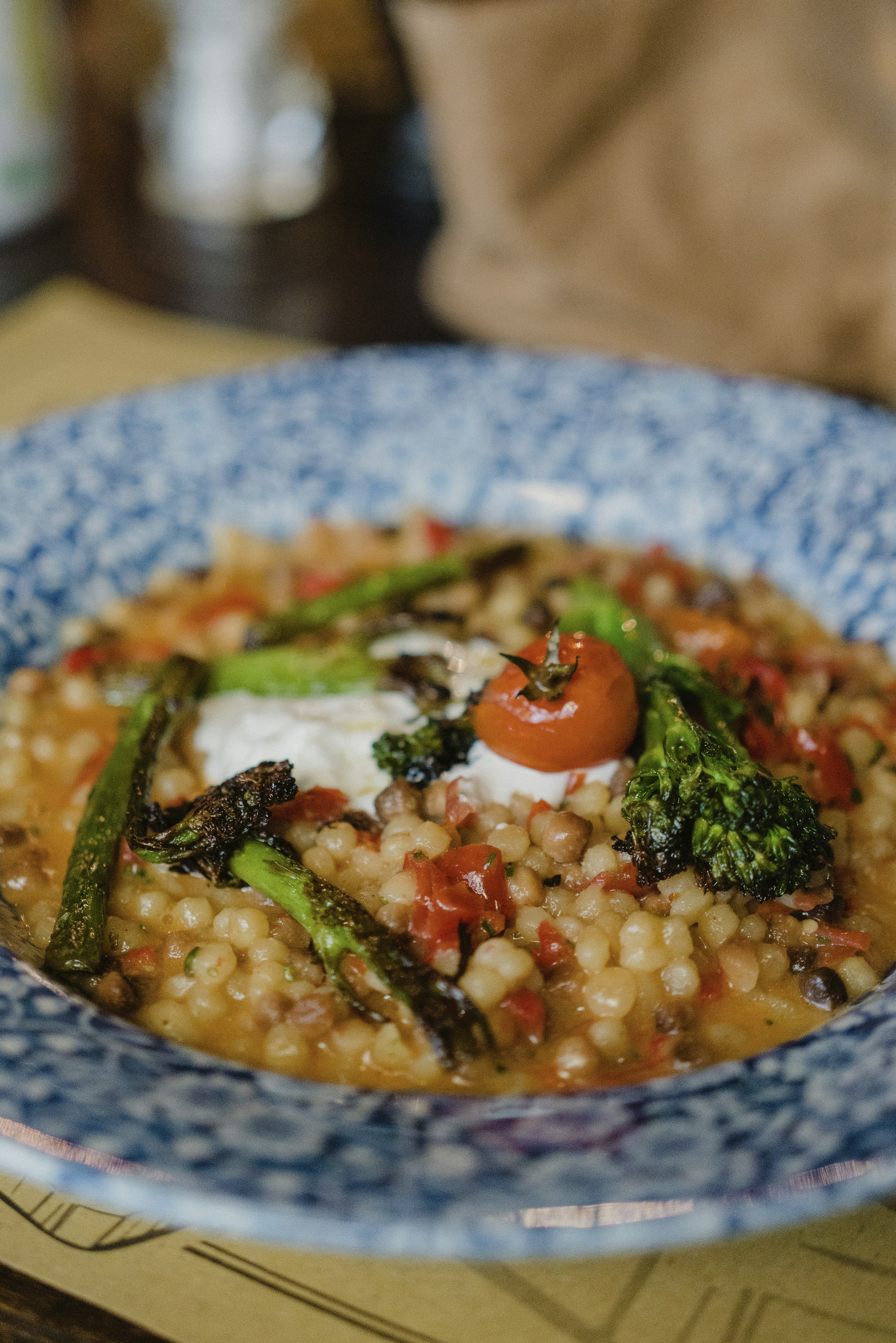a blue and white bowl filled with food on top of a table
