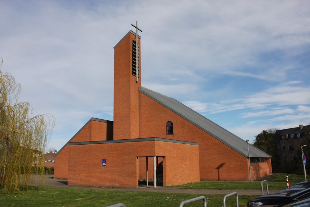a red brick church with a steeple and a cross on top