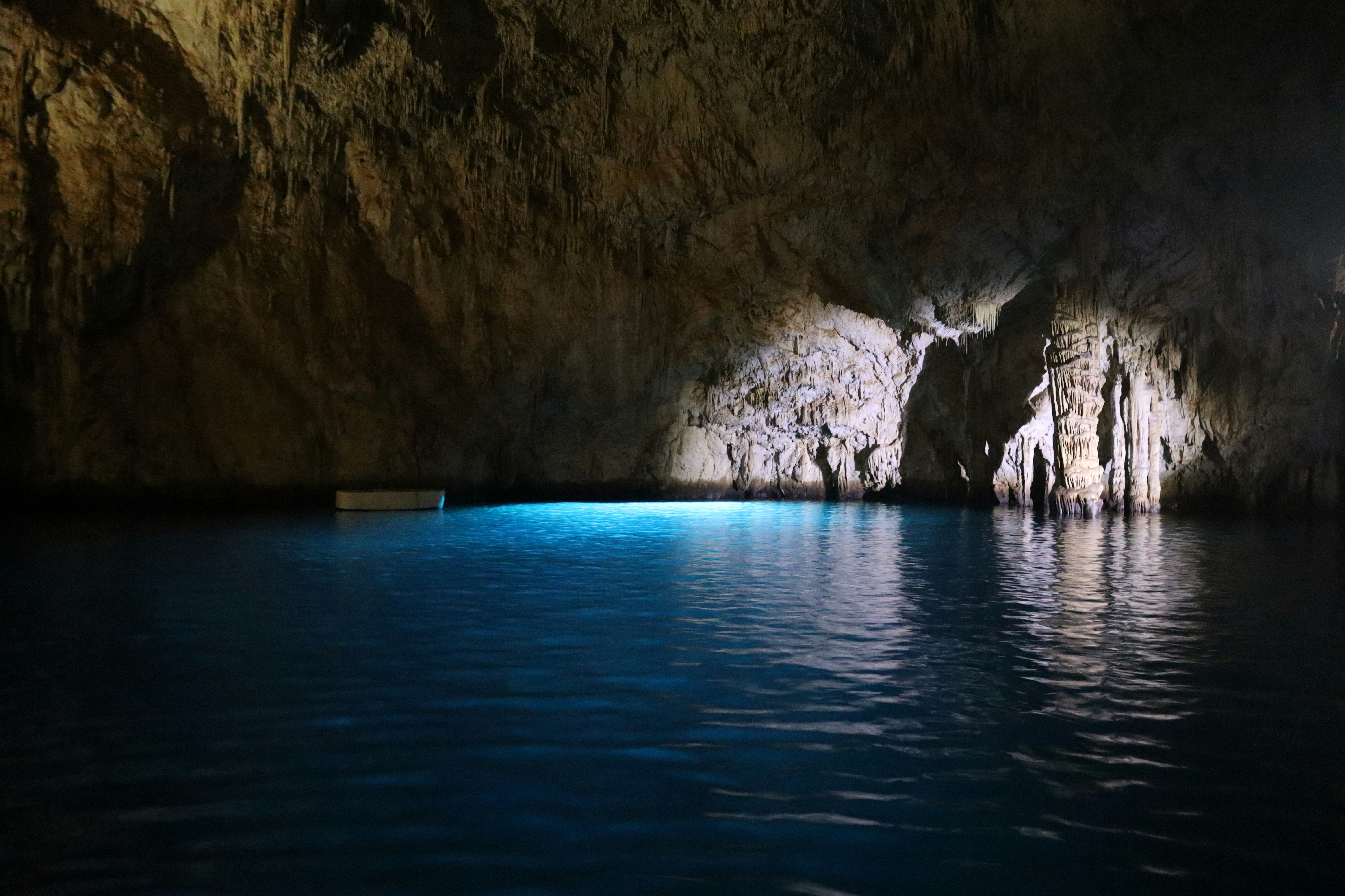 a boat is in the water near a cave