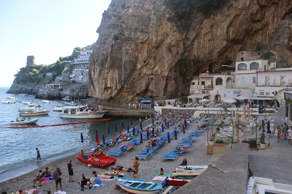 a group of people on a beach next to a cliff