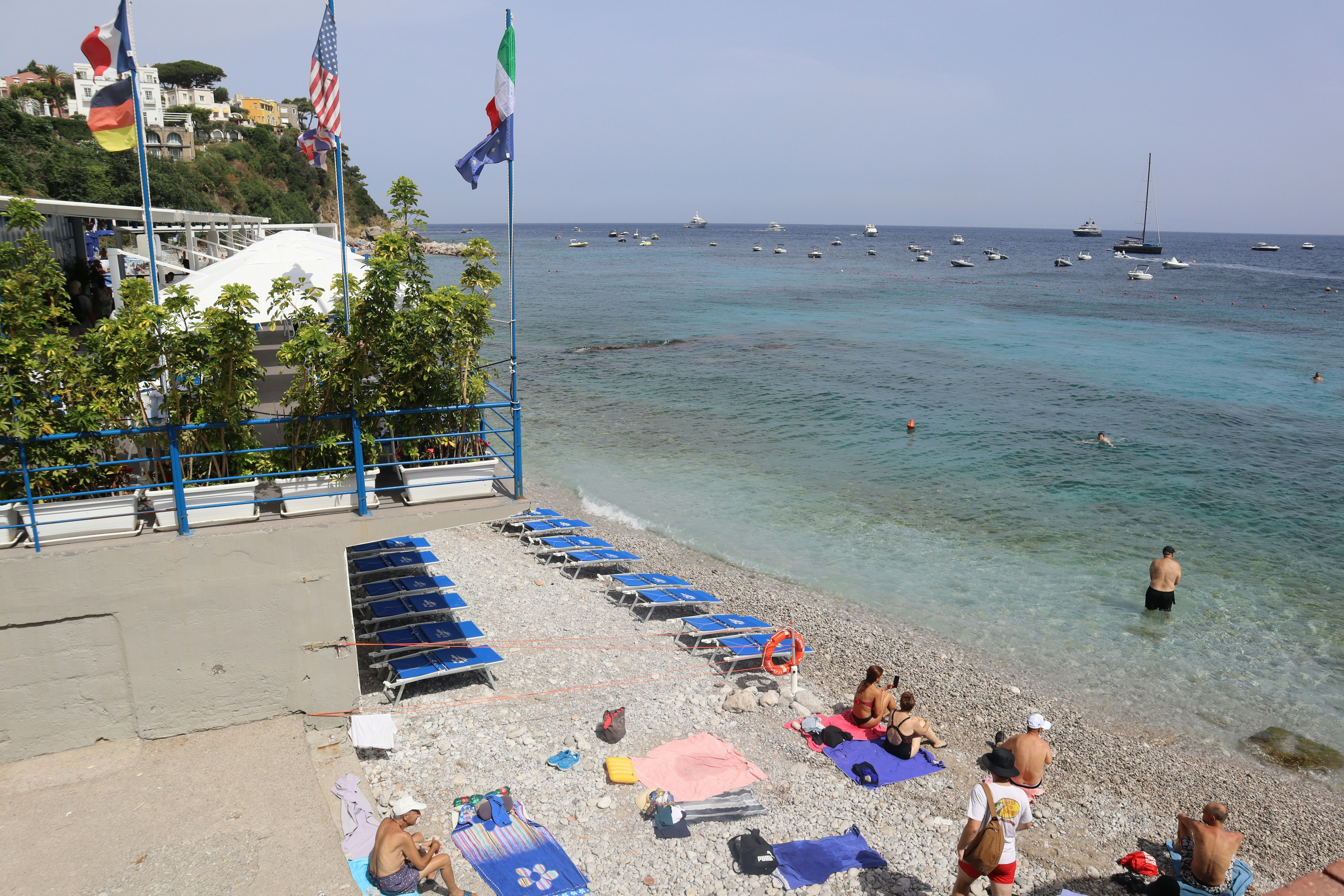a group of people sitting on top of a sandy beach
