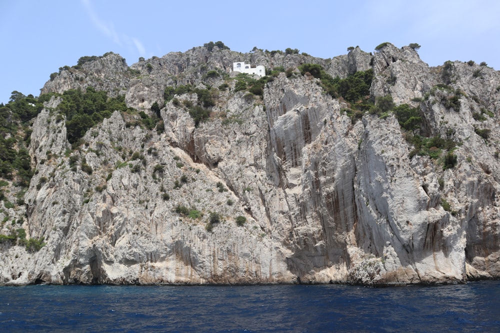 a house on top of a rock outcropping in the ocean