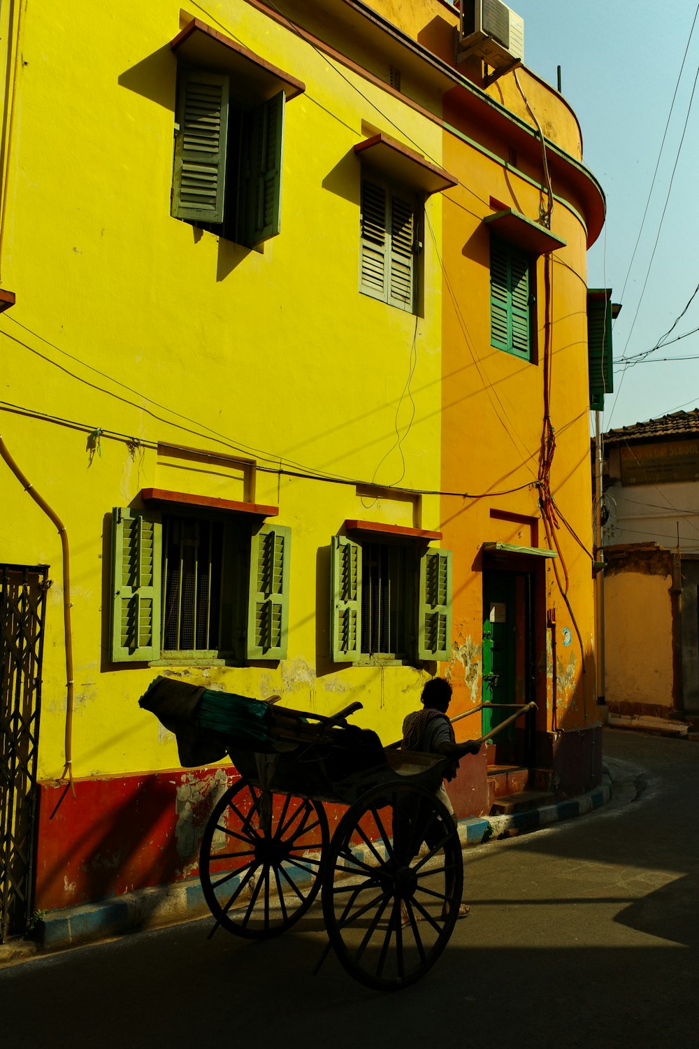 a horse drawn carriage in front of a yellow building