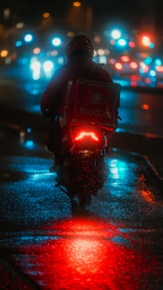 a man riding a motorcycle down a street at night