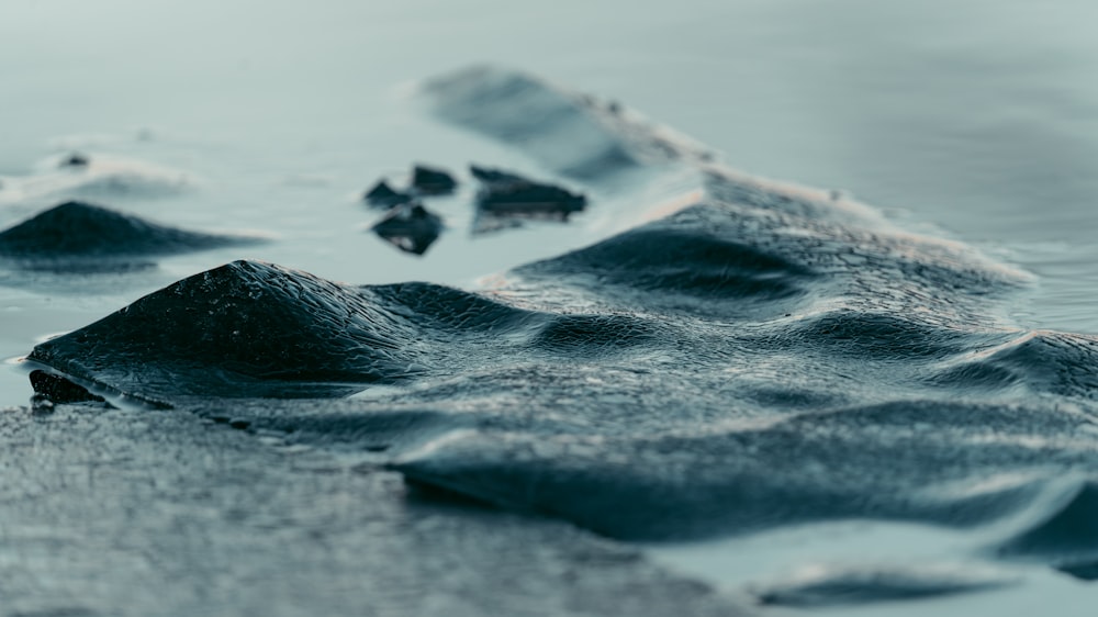 a group of rocks sitting on top of a body of water