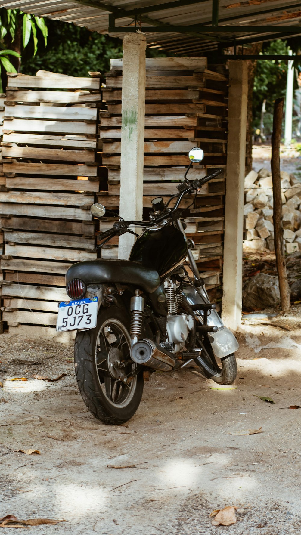 a black motorcycle parked under a wooden structure