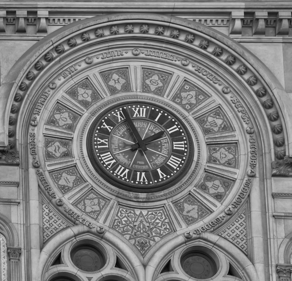 a black and white photo of a clock on the side of a building