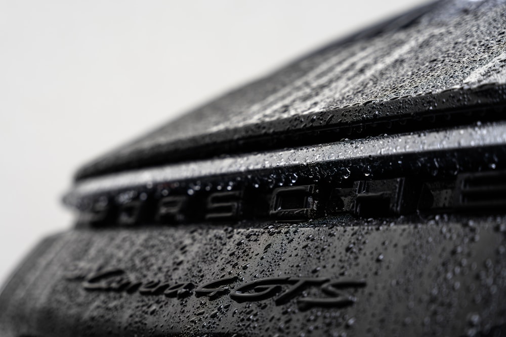 a close up of a black car with rain drops on it