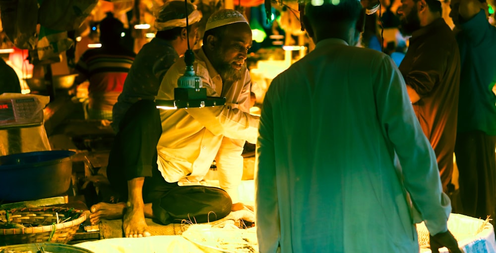 a group of people standing around a table with food on it