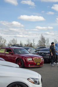 a group of people standing in a parking lot next to parked cars