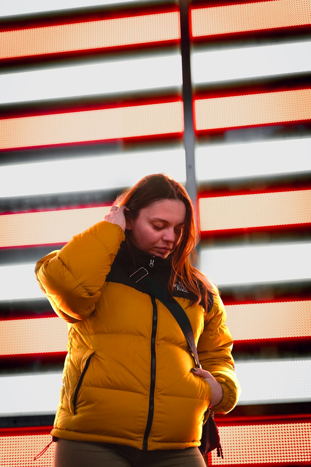 a woman in a yellow jacket is talking on her cell phone