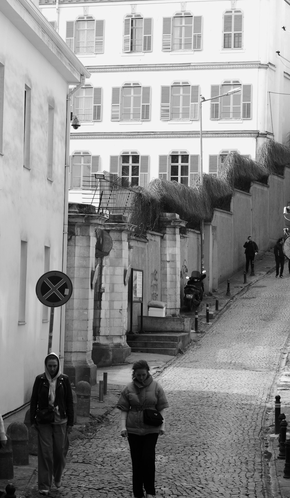 a group of people walking down a cobblestone street