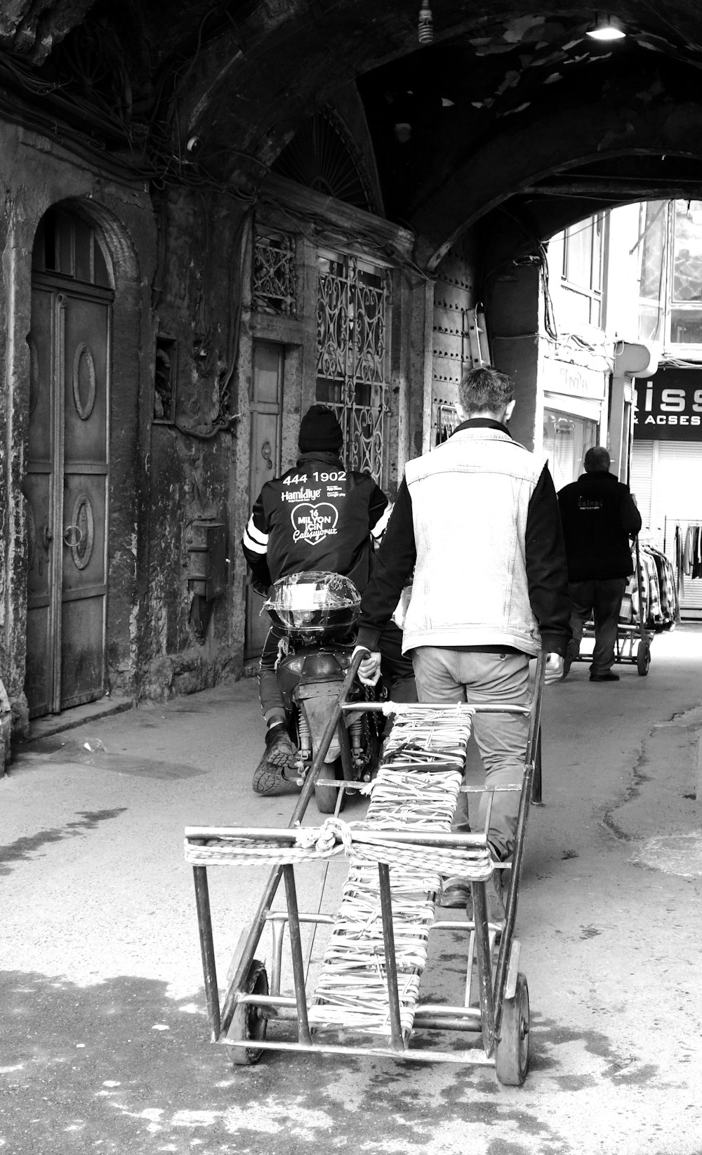 una foto in bianco e nero di un uomo che spinge un carrello
