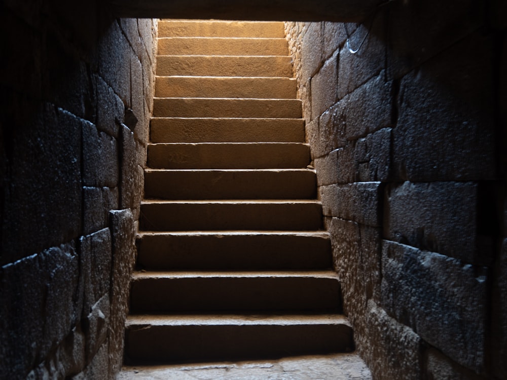 a set of steps leading up to a light at the end of a tunnel