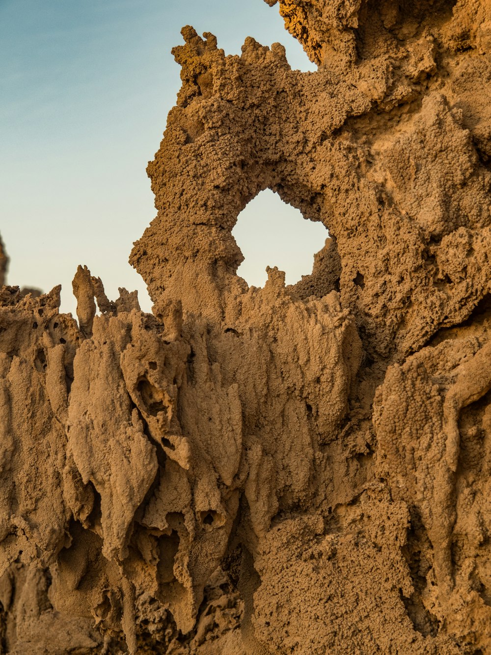 a close up of a rock formation with a blue sky in the background