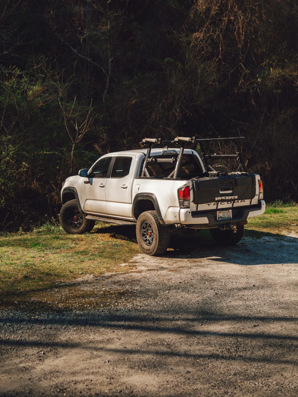 a white truck parked on the side of a dirt road