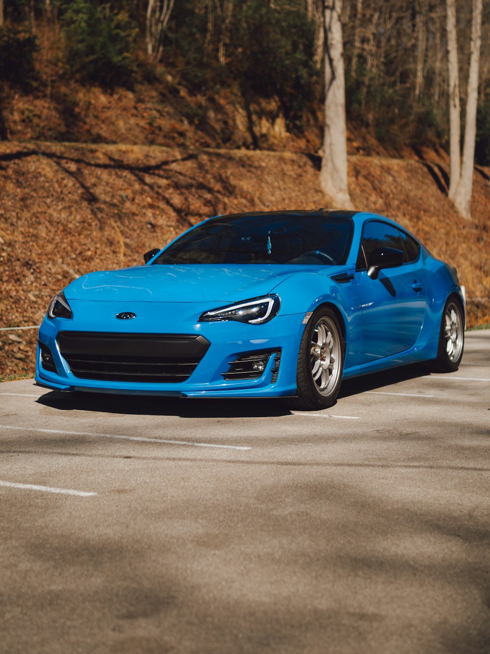 a blue sports car parked in a parking lot