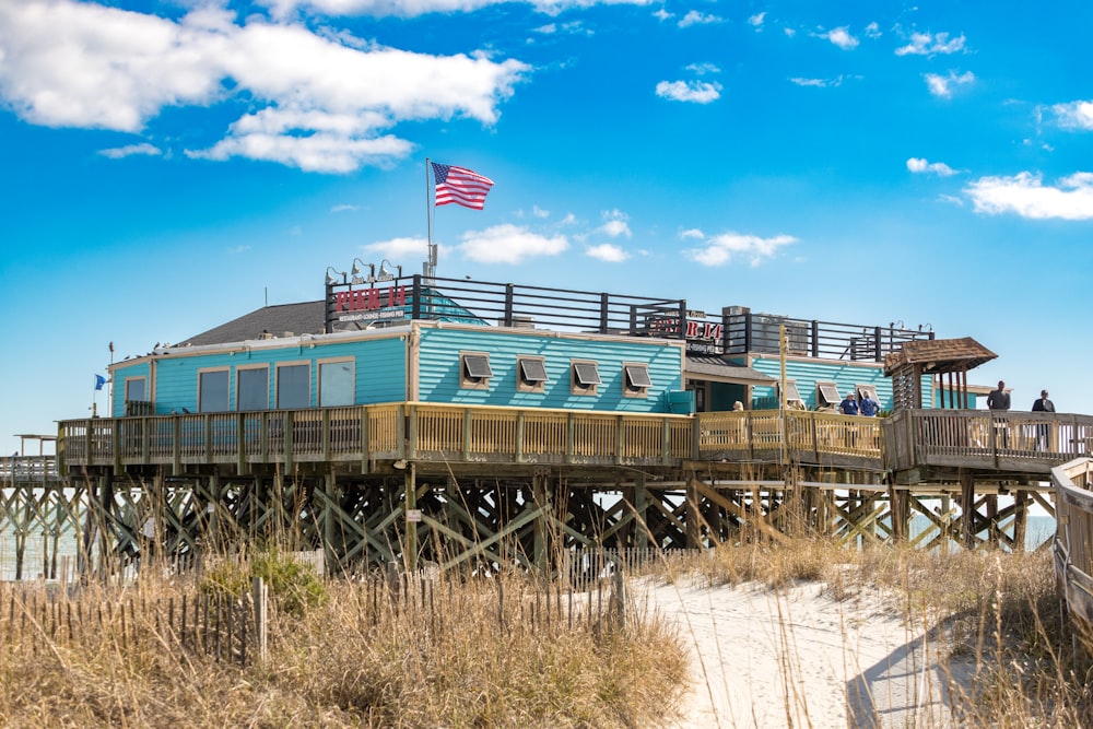 a blue house sitting on top of a wooden pier