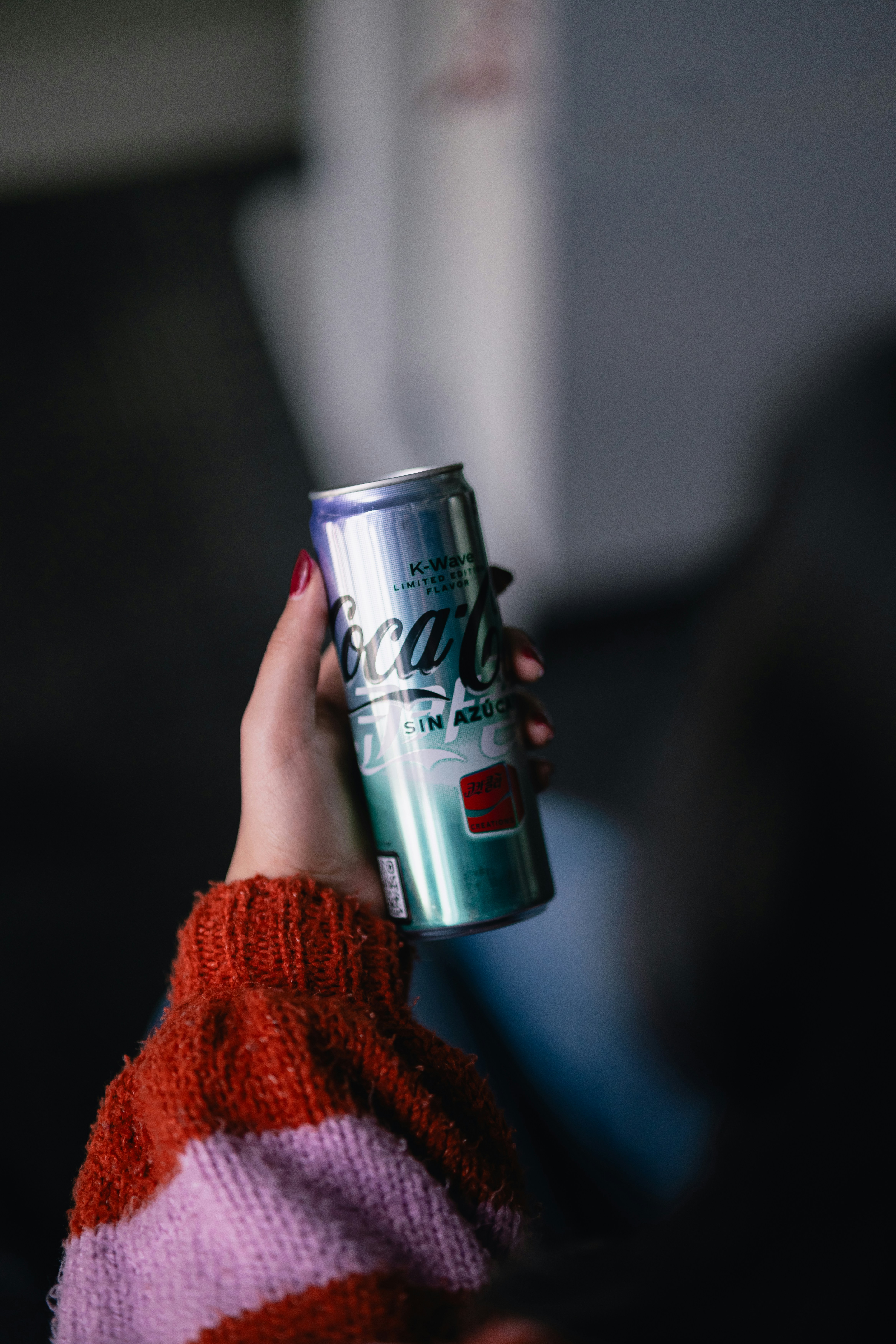 a person holding a can of soda in their hand