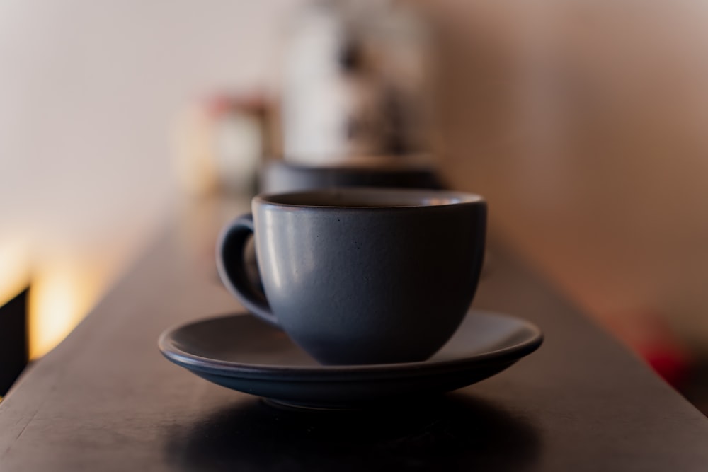 a black coffee cup sitting on top of a saucer