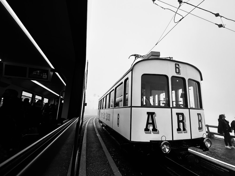 una foto in bianco e nero di un treno in una stazione