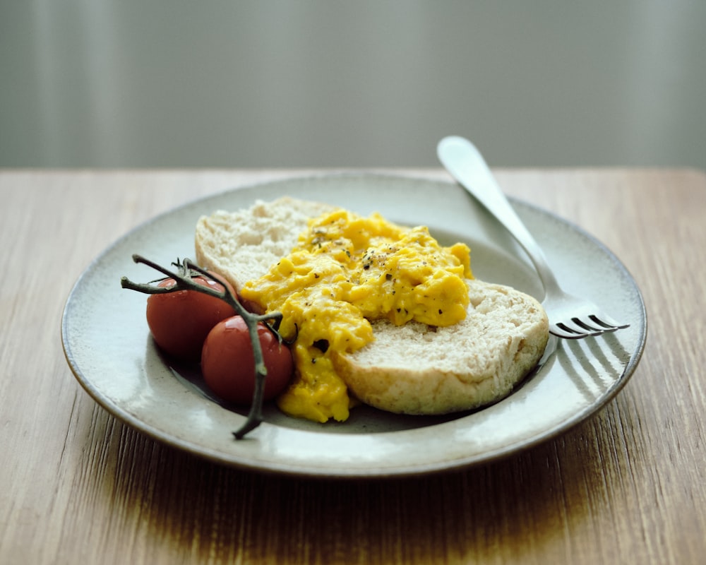 a plate with eggs, bread and tomatoes on it