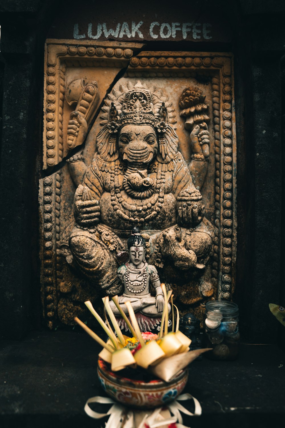 a statue of a hindu god with chopsticks in front of it