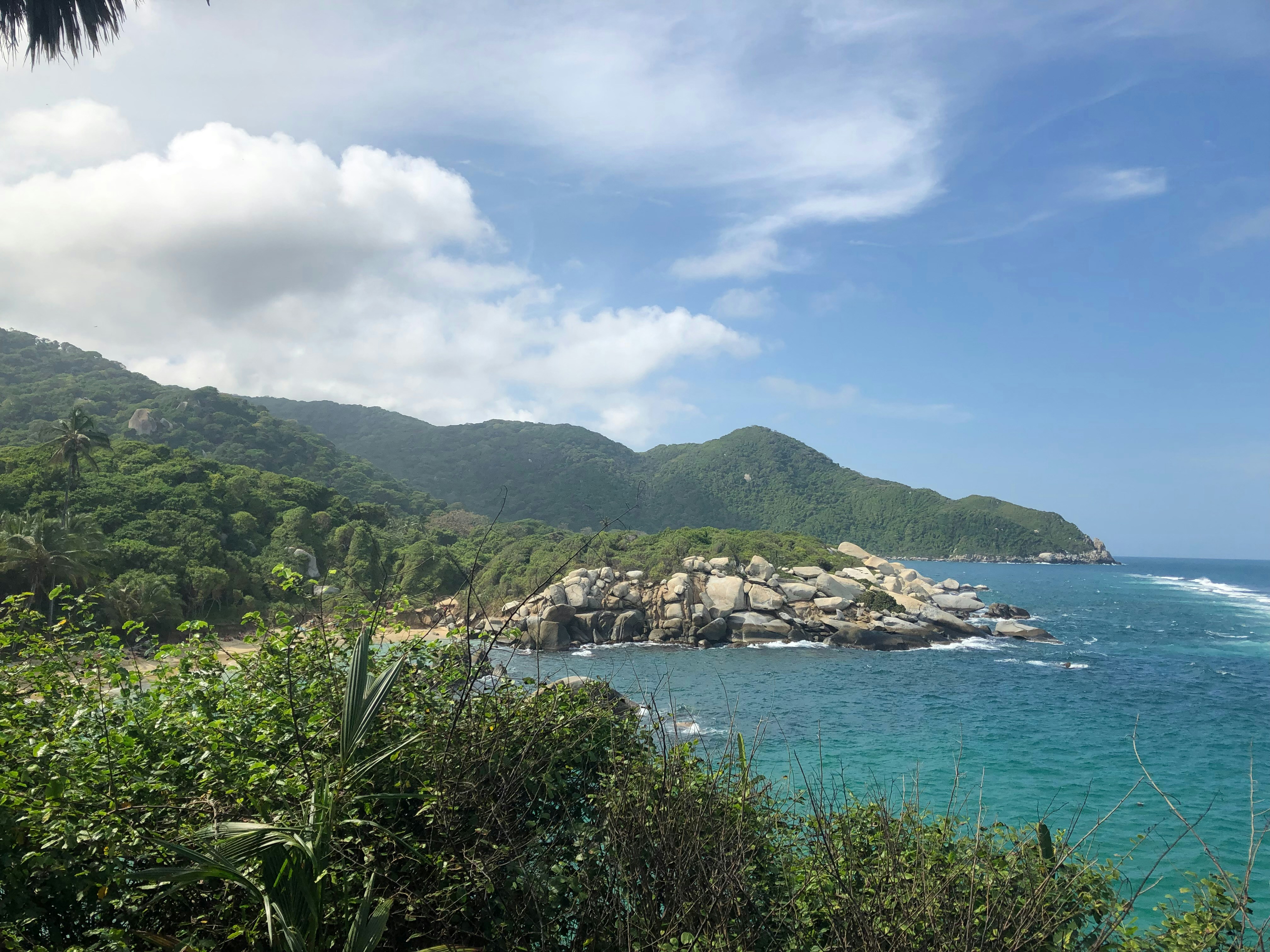 a body of water surrounded by a lush green hillside