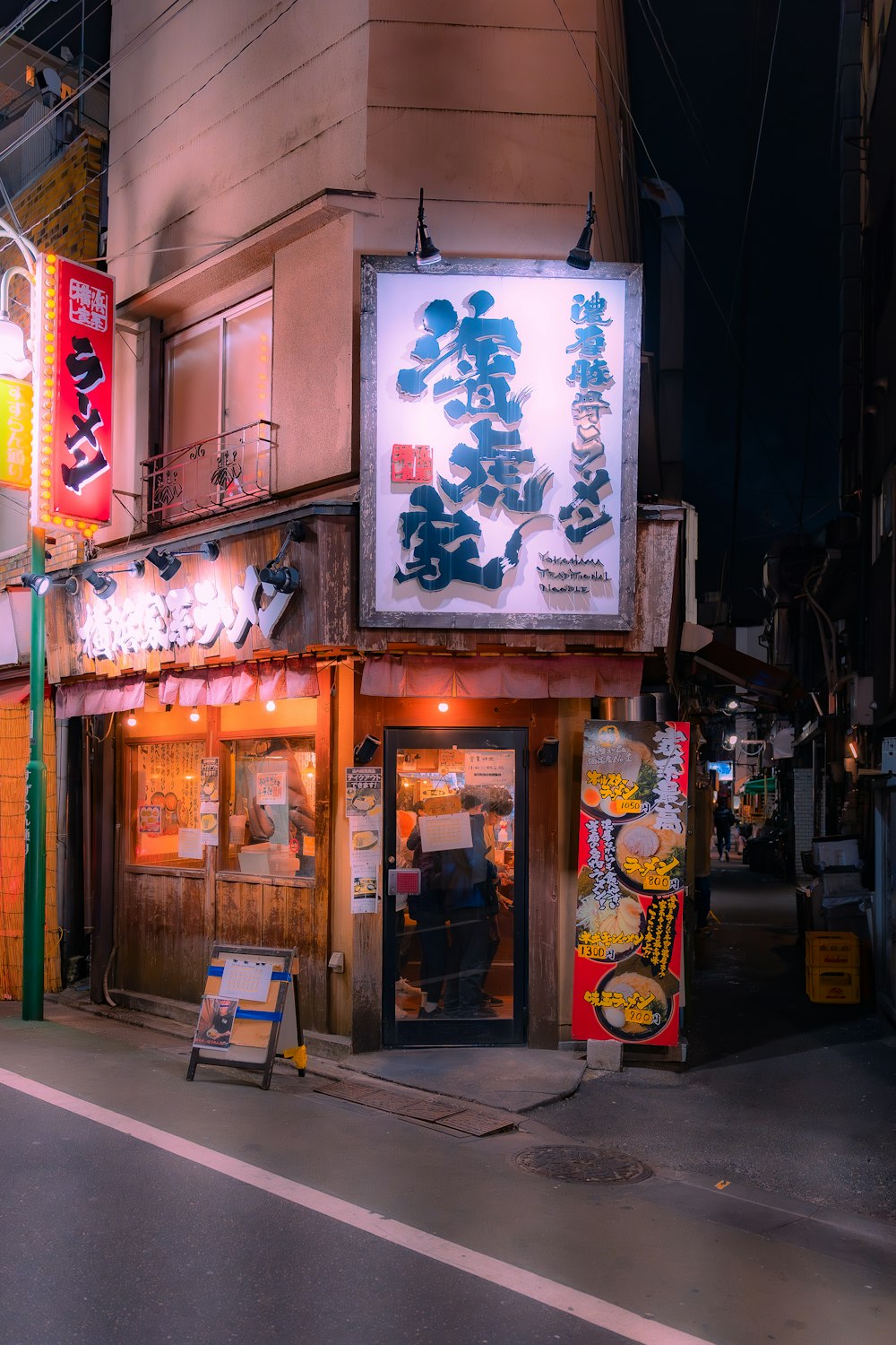 a city street at night with a chinese restaurant on the corner