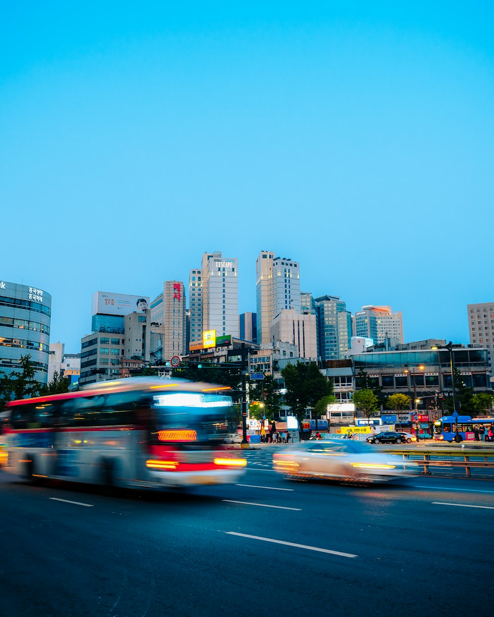 a city street filled with traffic next to tall buildings