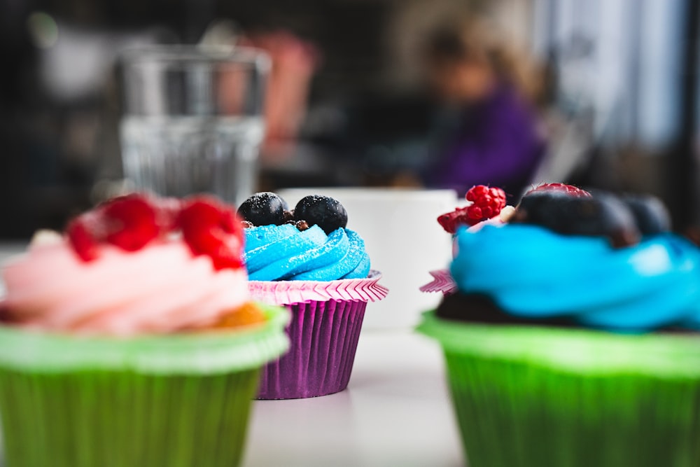 a close up of three cupcakes on a table