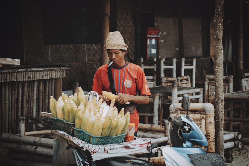 a man standing next to a table filled with bananas