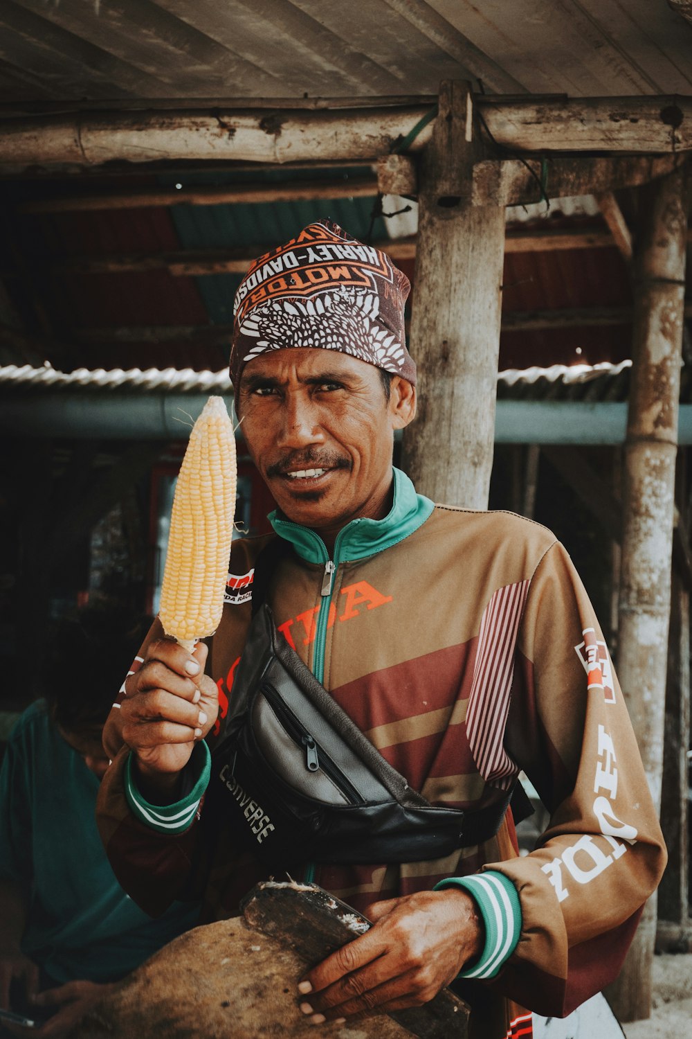 a man holding a corn cob in his hand