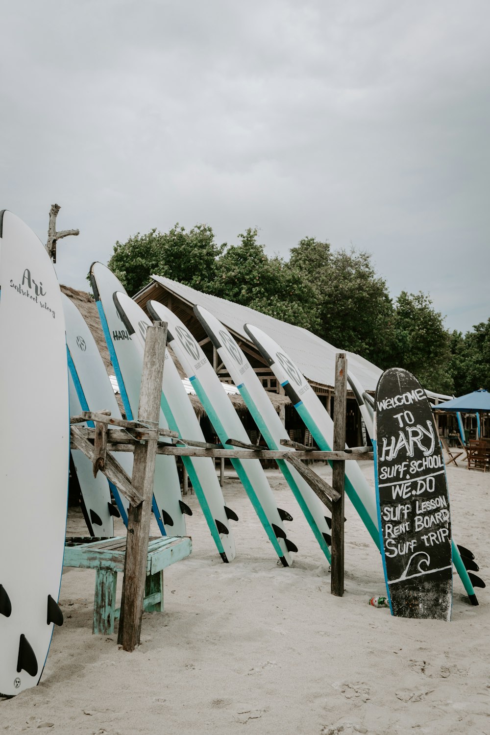 a bunch of surfboards that are leaning against a fence