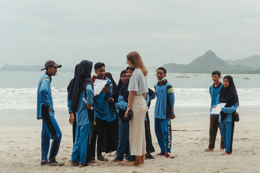 a group of people standing on top of a sandy beach