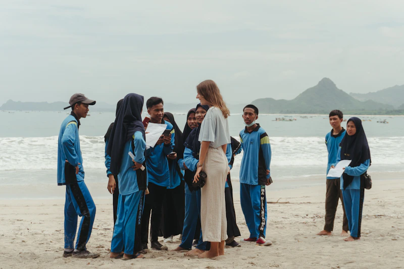 A group of people with herpes standing on top of a sandy beach