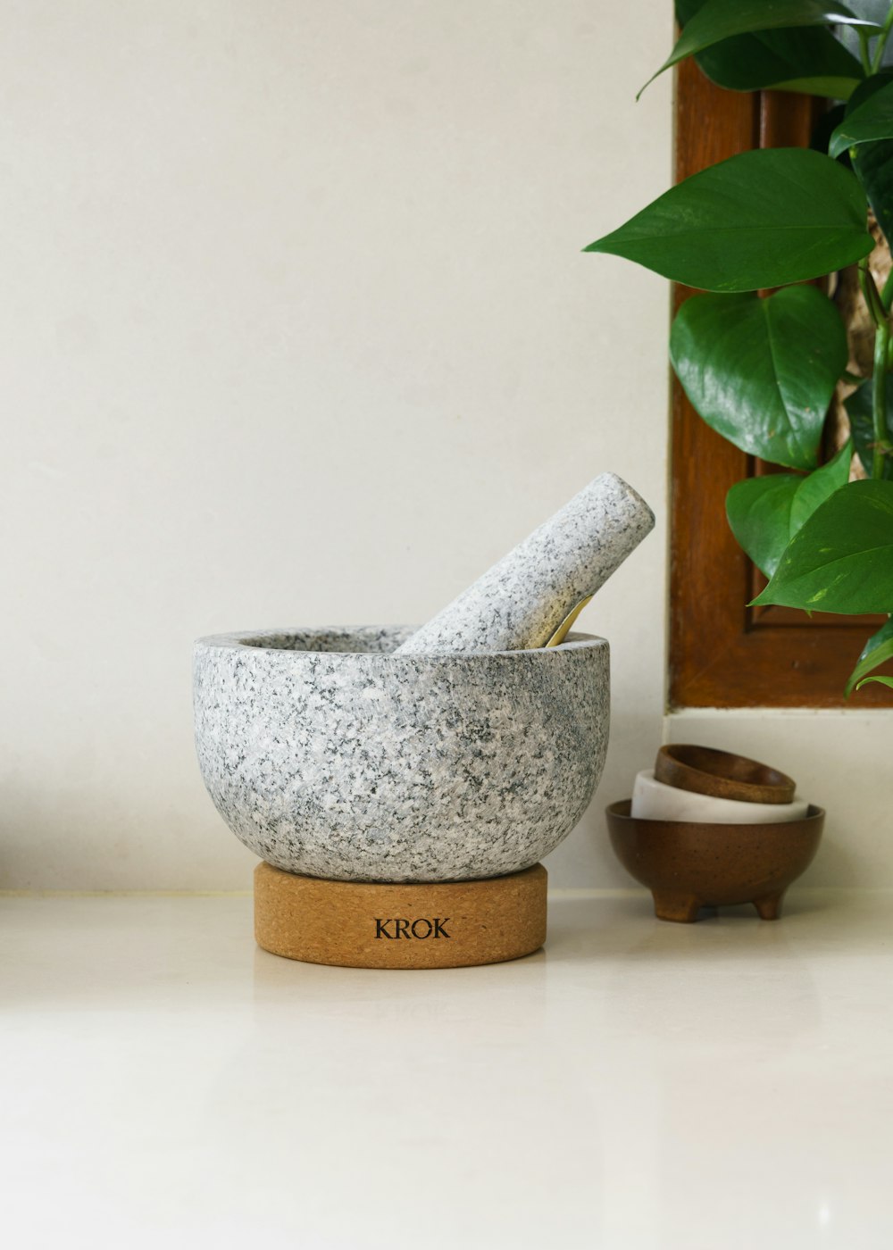 a mortar and mortar bowl sitting on a counter next to a potted plant