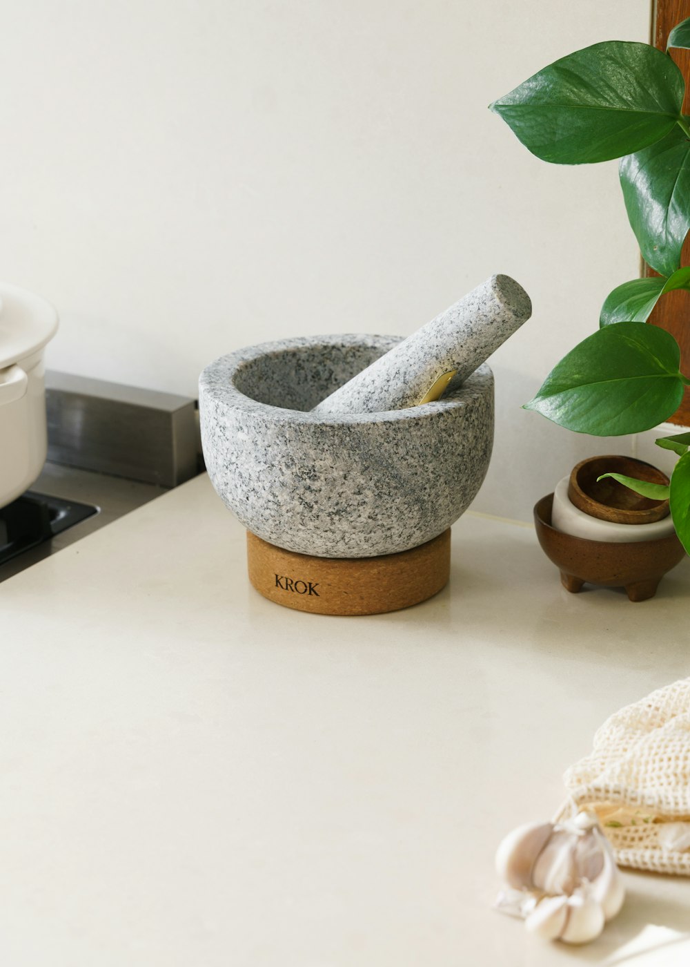 a mortar and mortar bowl sitting on a counter next to a potted plant