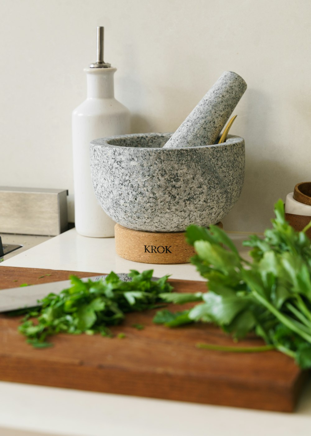 a cutting board with a knife and a mortar bowl on it