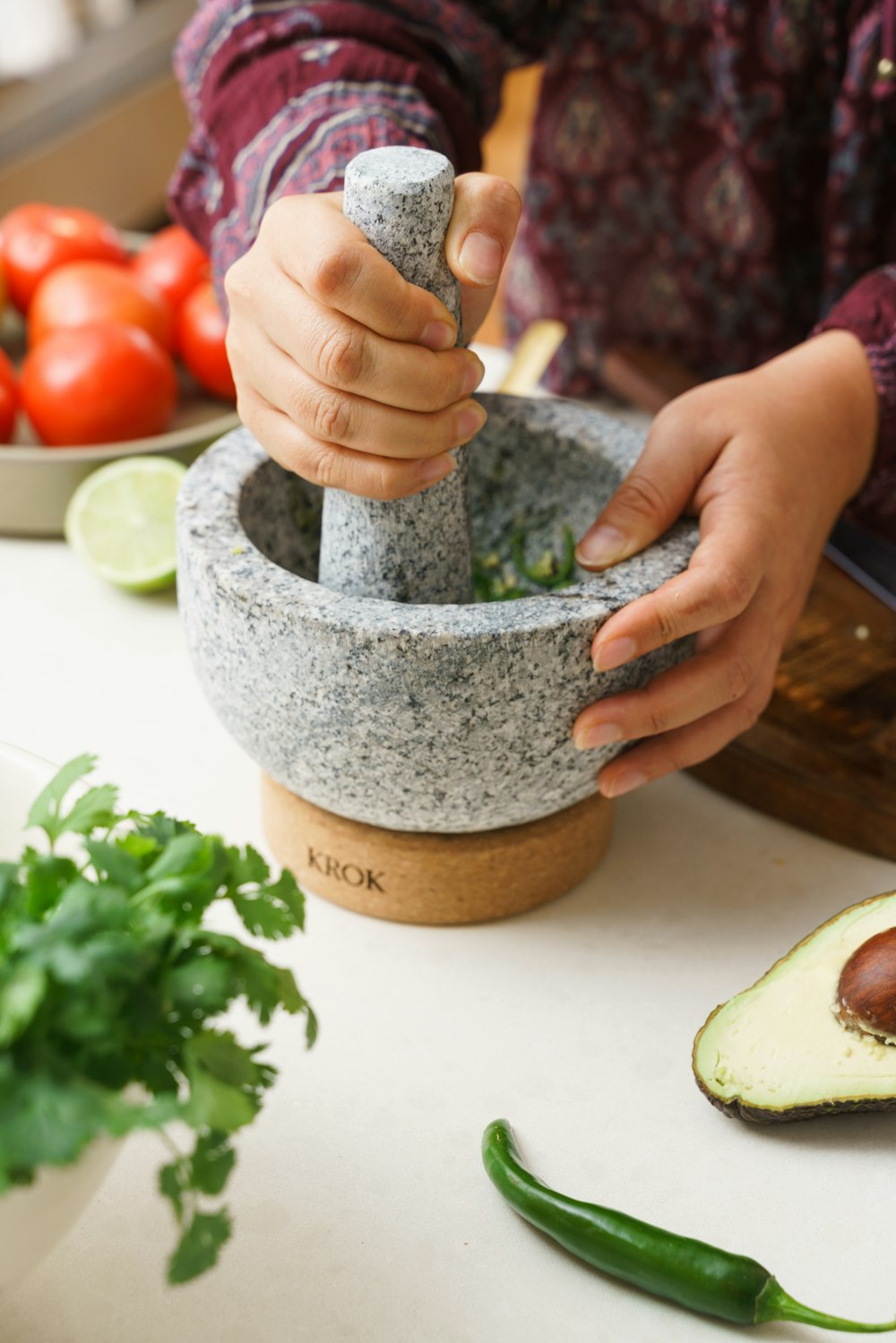 a person is using a mortar to make a salad