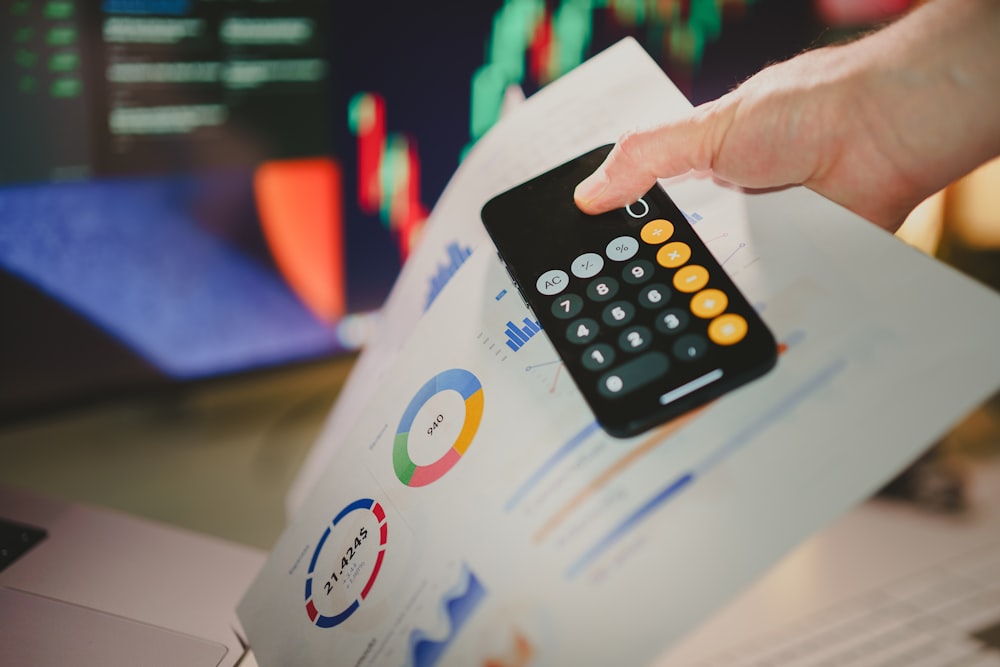 a person holding a calculator over a piece of paper