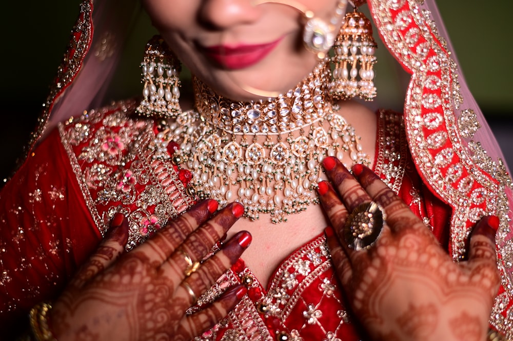 a woman wearing a red and gold bridal outfit