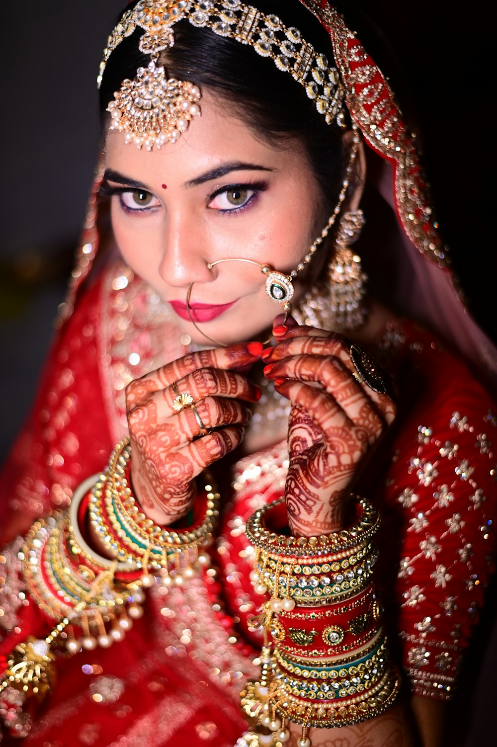 a woman in a red outfit with jewelry on her hands