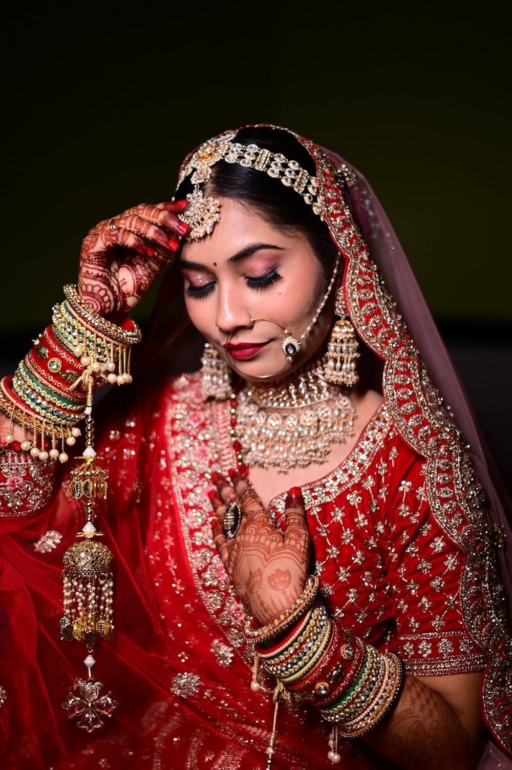 a woman in a red and gold bridal outfit