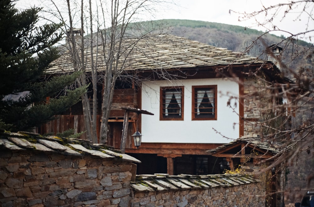 a house with a stone wall and a roof