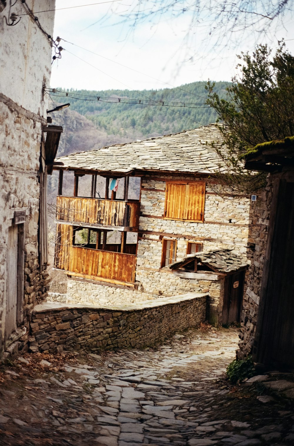 a cobblestone street with a stone building on the side