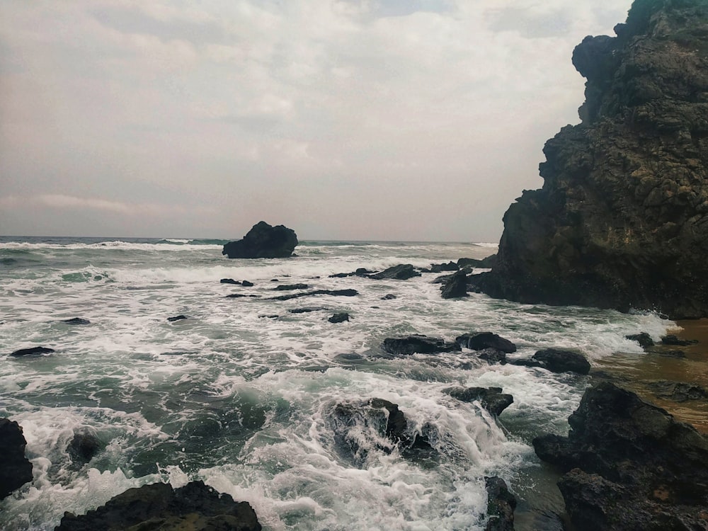 a body of water surrounded by rocks on a cloudy day