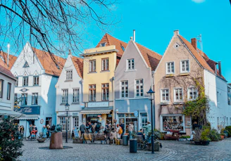 a group of people walking around a cobblestone street