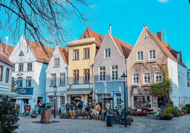 a group of people walking around a cobblestone street